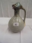 An unusual stoneware jug with handle. A birds head forms the lid and spout.