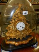 A Spelter mantle clock under glass dome.