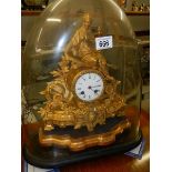 A Spelter mantle clock under glass dome.