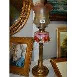 A Brass column oil lamp with floral pink font and acid etched shade.