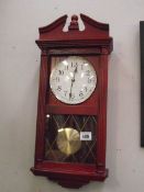 A constant red wood stained quartz wall clock