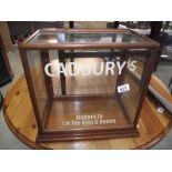 A table top display cabinet with Cadbury advertising.