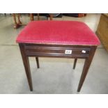 An Edwardian mahogany piano stool with contents.