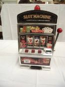 A vintage toy slot machine 1 arm bandit, battery operated. Height 38cm at highest point.