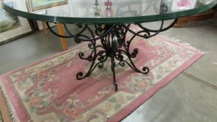 A good quality designer table with glass top and wrought iron base. 115 cm diameter.