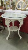 A cast iron pub table with glass top.