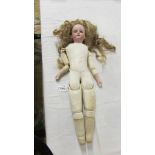 A Victorian porcelain headed doll with kid body, wig loose.