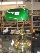 A brass desk/bankers lamp with green glass shade