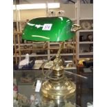 A brass desk/bankers lamp with green glass shade