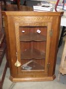 An oak wall corner cupboard.