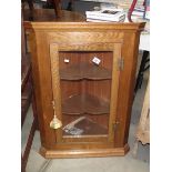 An oak wall corner cupboard.