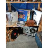 An old tape recorder and 2 shelves of records.