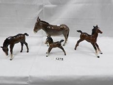 A Beswick donkey and 3 Beswick foals.