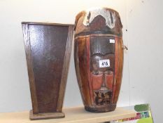 A carved tribal bongo drum and a wooden planter