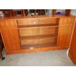 A teak glazed cabinet.