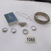 4 silver rings, a silver Maltese cross on silver chain, a silver butterfly brooch,