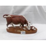 A Royal Doulton Hereford cow with calf.