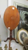 An oval mahogany tripod tip top occasional table.