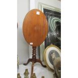 An oval mahogany tripod tip top occasional table.