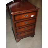 A darkwood stained faux chest of drawers cupboard