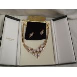 A boxed gold plated necklace with matching earrings