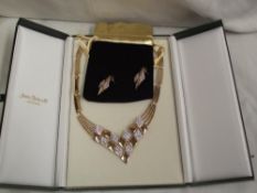 A boxed gold plated necklace with matching earrings