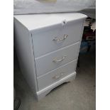 A white 3 drawer bedroom chest.