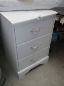 A white 3 drawer bedroom chest.