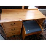 A pine effect desk and stool.