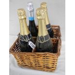 Four bottles of sparkling wind in a wicker basket.