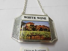 A silver plate and enamel wine bottle label.