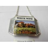 A silver plate and enamel wine bottle label.