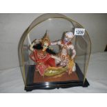 A pair of good quality oriental dolls in dome shaped cabinet. 32 x 28 cm.