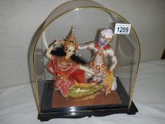 A pair of good quality oriental dolls in dome shaped cabinet. 32 x 28 cm.