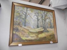 A gilt framed oil on board woodland scene