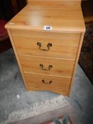 A pine effect 3 drawer bedside chest.