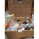 A wicker basket containing sewing items.