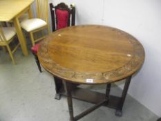 A good oak drop leaf round table with carved detail around edge