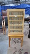 A small wicker 5 drawer chest on stand.