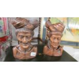 A pair of carved wood male and female busts.