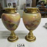 A pair of Royal Worcester porcelain ovoid vases, the moulded neck gilded,