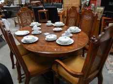 An oak dining table and 4 cane back chairs.