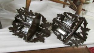 A pair of corner wall brackets with mirrors.