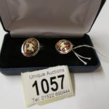 A pair of silver and enamel cuff links with nude figure.