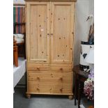 A pine linen press with 2 doors and 2 over 2 drawer base.