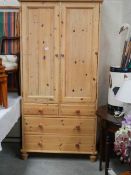 A pine linen press with 2 doors and 2 over 2 drawer base.