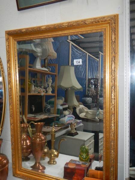 A gilt framed mirror.