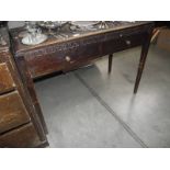 An Edwardian mahogany 2 drawer desk/table with geometric carved front and leather inset top.