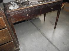 An Edwardian mahogany 2 drawer desk/table with geometric carved front and leather inset top.