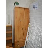 A pine effect 2 door, 2 drawer wardrobe.